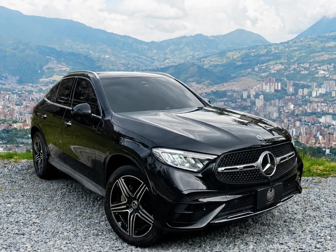Mercedes-Benz GLC 300 negra con rines bicolor, de tres cuartos frontal, sobre un mirador con Medellín al fondo.
