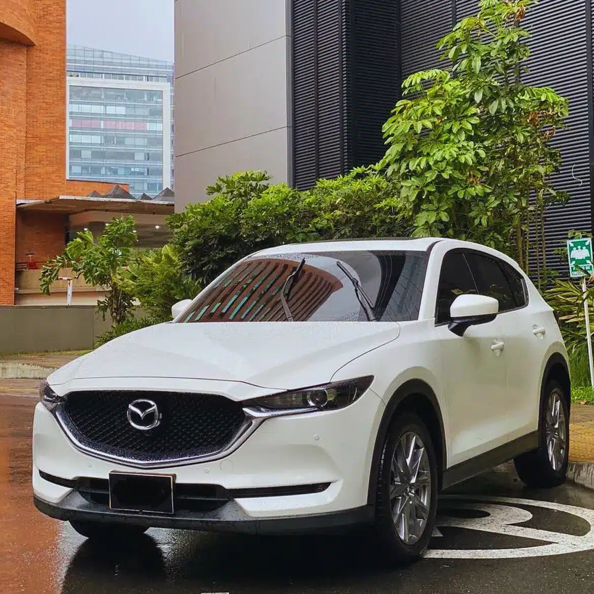 Mazda 2 gris oscuro de Majestic Rentacar parqueado en zona residencial.