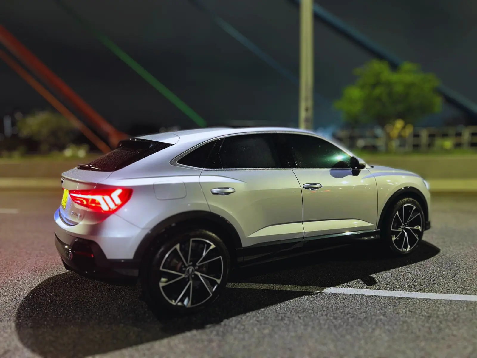 Audi Q3 Sportback blanco estacionado de noche, vista lateral trasera