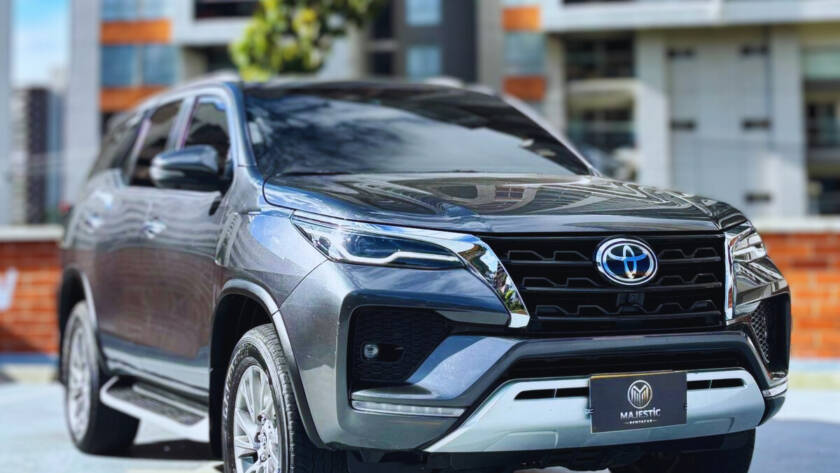 Toyota Fortuner negra modelo reciente estacionada en terraza con edificios residenciales al fondo